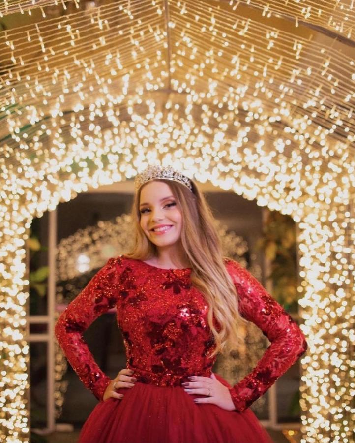 Debutante de vestido vermelho na entrada do Túnel de Microlâmpadas